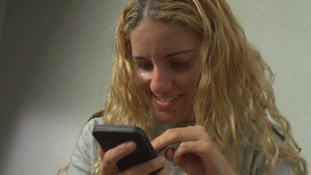 Adriana uses a smartphone