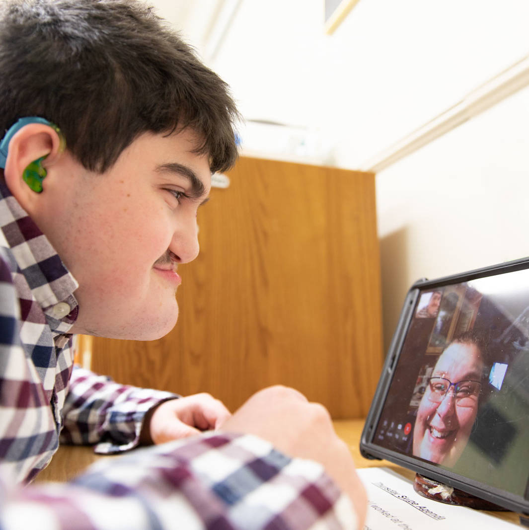 A man video chats on an a tablet with his mom