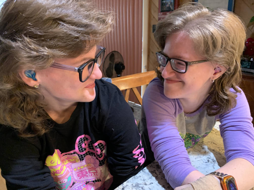 Sisters Tina and Lena Stolper look at each other with happy faces.