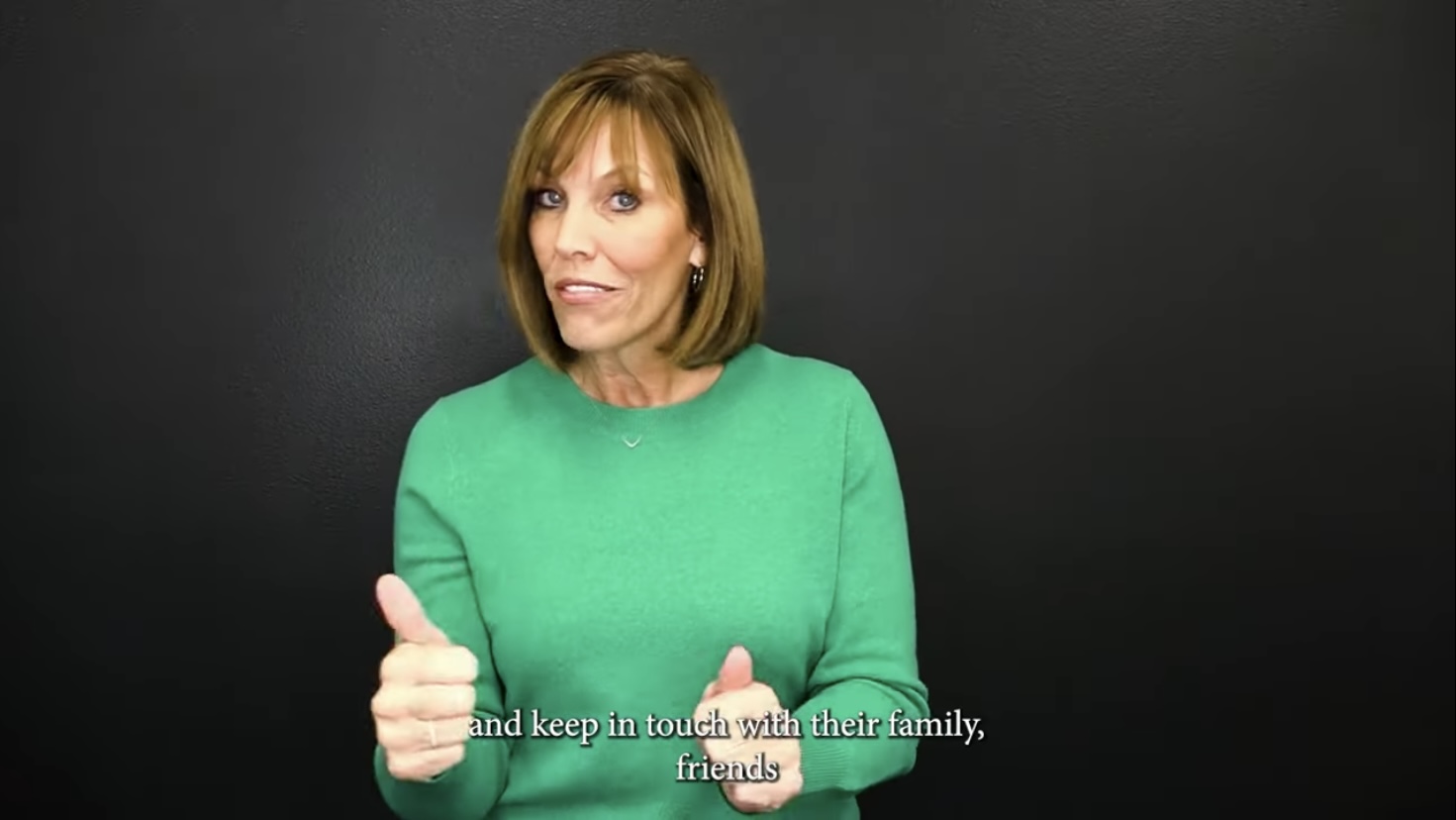 A screenshot from the ASL video shows a woman in a green sweater mid-signing.