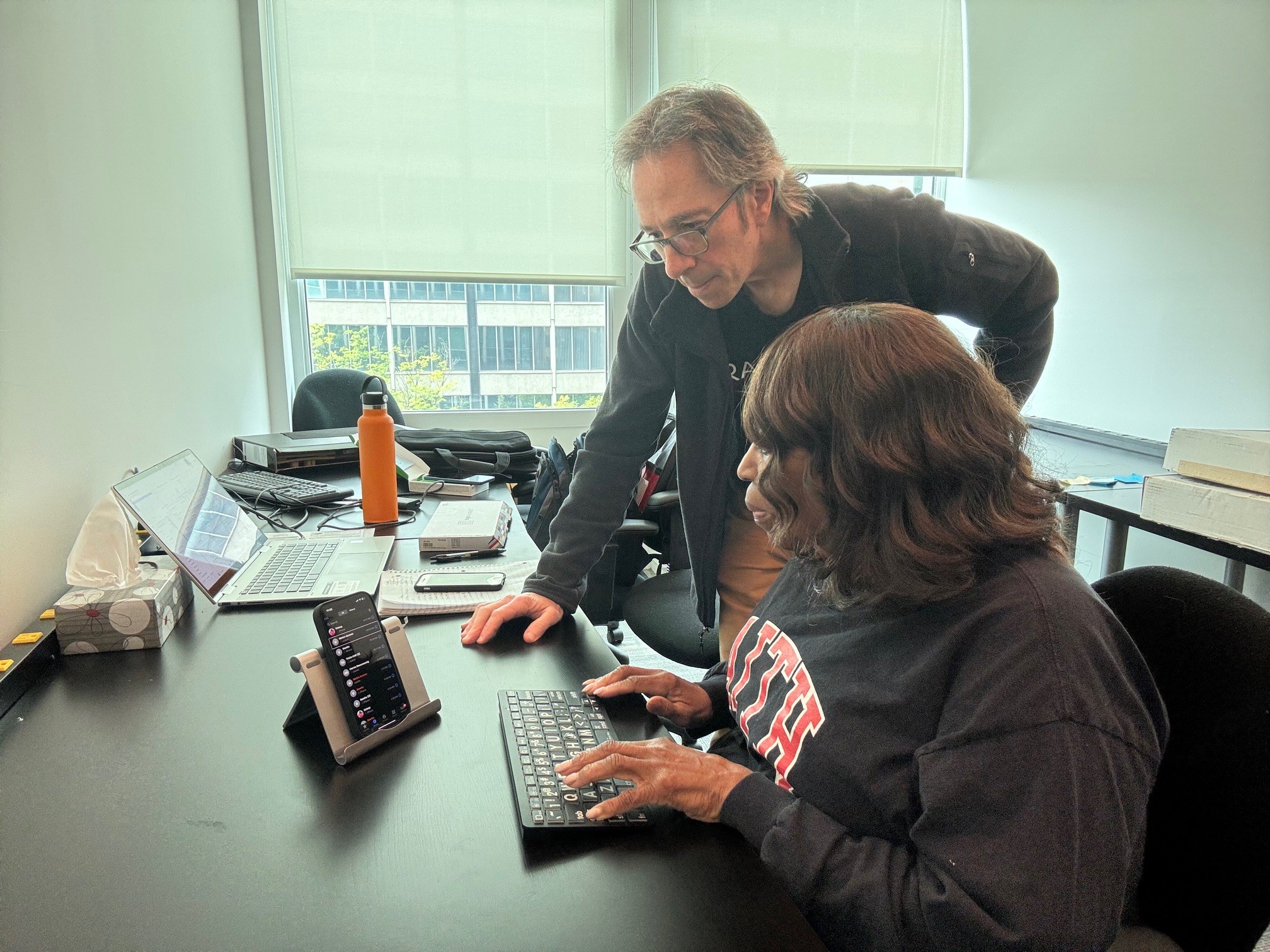 A man and a woman work together at a desk.